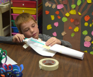 Max Hersom, a third grader at Whitefield Elementary School, attempts to build a rocket out of paper, a straw, and tape. (Jessica Clifford photo)