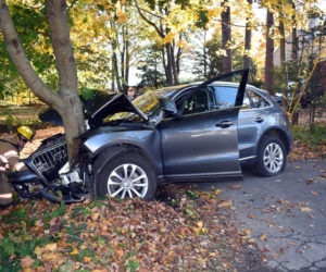 A firefighter inspects an Audi SUV after a crash near Wiscasset village the afternoon of Saturday, Oct. 26. (Alexander Violo photo)