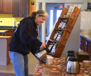 Crystal Lewis pours cream into her coffee at The Morris Farm, the location for the Wiscasset Winter Farmers Market. (Jessica Clifford photo)