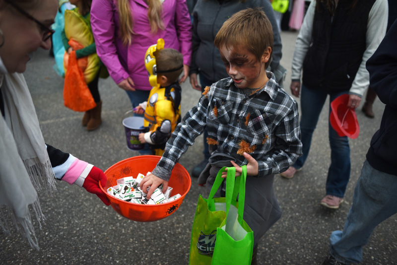 Mitchell Collins, of Round Pond, dressed as a werewolf, gets some Junior Mints from Lisa Pinkham during a trunk-or-treat event at Great Salt Bay Community School in Damariscotta on Oct. 31 of last year. (LCN file photo)