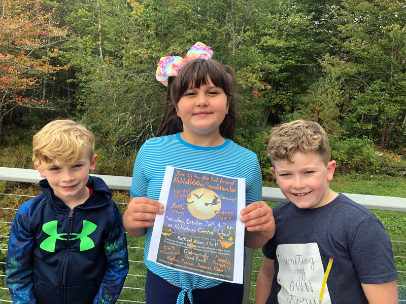 From left: Noah Irons, JoJo Shea, and Brayden Irons with a 2019 NobleBOOro Spooktacular poster.