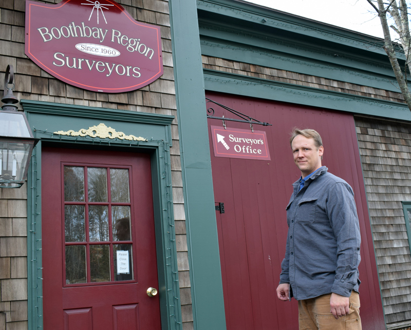 Nicholas Plumer outside the office of Boothbay Region Surveyors at the old town garage in Boothbay. Plumer, of Bristol, bought the long-standing business in 2017 and recently changed the name. (Evan Houk photo)