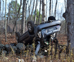 A 2006 Mazda Tribute lies on its roof on a stone wall in Dresden on Monday, Nov. 4. The driver and passenger were treated and released at Maine Medical Center in Portland, according to the hospital. (Jessica C?lifford photo)