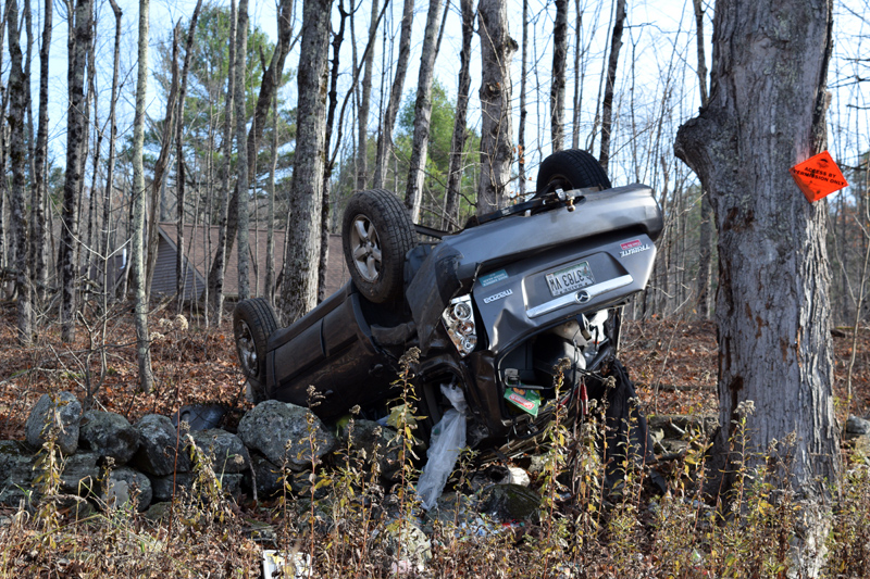 A 2006 Mazda Tribute lies on its roof on a stone wall in Dresden on Monday, Nov. 4. The driver and passenger were treated and released at Maine Medical Center in Portland, according to the hospital. (Jessica C?lifford photo)