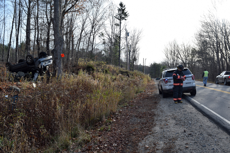 Emergency personnel respond to a rollover on Middle Road in Dresden on Monday, Nov. 4. The vehicle is at rest on a stone wall at left. (Jessica Clifford photo)