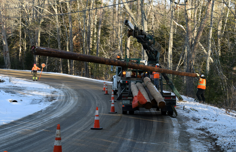 Utility workers install new poles near the former landfill at the corner of Biscay and Standpipe roads in Damariscotta on Dec. 20. A contractor is installing a solar array on the landfill site. (Evan Houk photo)