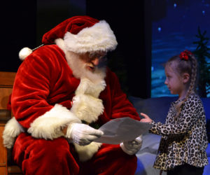 Santa reads a letter from Cali Noriega, 4, of Bristol, during a Villages of Light event at the Lincoln Theater in Damariscotta on Saturday, Nov. 30. (Maia Zewert photo)