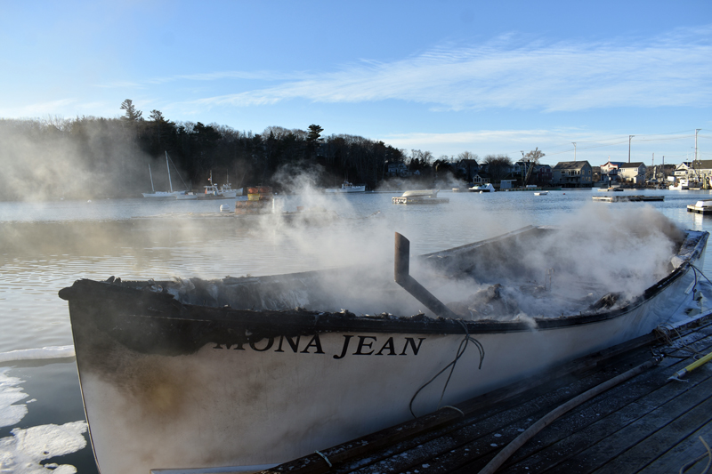 Smoke rises from the remains of the Mona Jean at Eugley Landing in South Bristol on Christmas Eve. The boat caught fire at its mooring and firefighters towed it to the dock. (Alexander Violo photo)