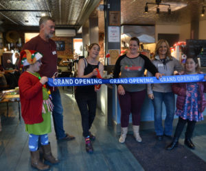 Cupacity owner Susan Murphy cuts a grand opening ribbon in her cafe surrounded by Damariscotta Region Chamber of Commerce board members Wayne Farrin, Terri Herald, and Jane Oliver-Gravel and her daughters Olive and Nolah. (Maia Zewert photo)