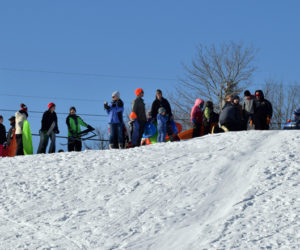 Parents, students, and staff from Bristol Consolidated School watch other sledders brave the hill at Wawenock Golf Club on family fun day, Monday, Jan. 20. The event was part of the WinterKids Winter Games. (Evan Houk photo)