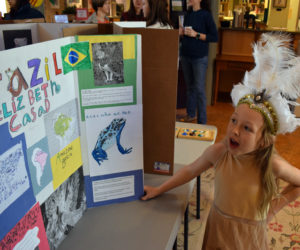 Elizabeth Casad, 8, of Bristol, answers a question about her project on Brazil during Homeschooler Cultural Day at Skidompha Library in Damariscotta on Thursday, Jan. 30. Fourteen homeschooled children from across Lincoln County participated in the event. (Evan Houk photo)