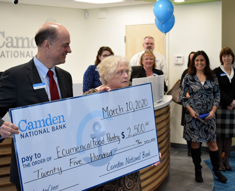 Greg Dufour, president and CEO of Camden National Bank, presents a $2,500 check to Jennifer Ober, president of the Ecumenical Food Pantry, during the grand opening of the bank's new branch in Damariscotta. (Evan Houk photo)