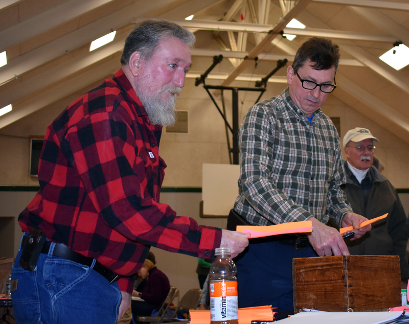 Somerville resident Steven Cooper (left) and Second Selectman Don Chase vote on the marijuana business ordinance during a special town meeting at Somerville School on Saturday, March 7. (Alexander Violo photo)