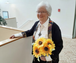 Shirley Tawney is proud of growing up in Kansas. She is pictured here with a sunflower plant. The sunflower is the state flower of her home state.