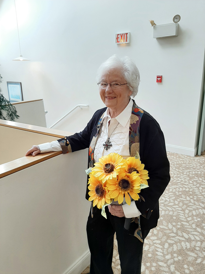 Shirley Tawney is proud of growing up in Kansas. She is pictured here with a sunflower plant. The sunflower is the state flower of her home state.
