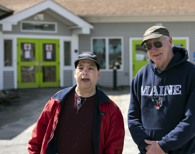 Shawn Rego (left) stands with Direct Support Professional Ed Kennedy in front of the Mobius Inc. community center in Damariscotta on March 31. Rego is in the habit of going to the center every day and continues to visit the building, despite the closure. (Bisi Cameron Yee photo)