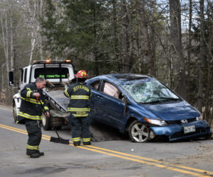 Firefighters sweep debris and help load a vehicle onto a tow truck after a crash on Bunker Hill Road in Jefferson the afternoon of Tuesday, April 7. (Alexander Violo photo)