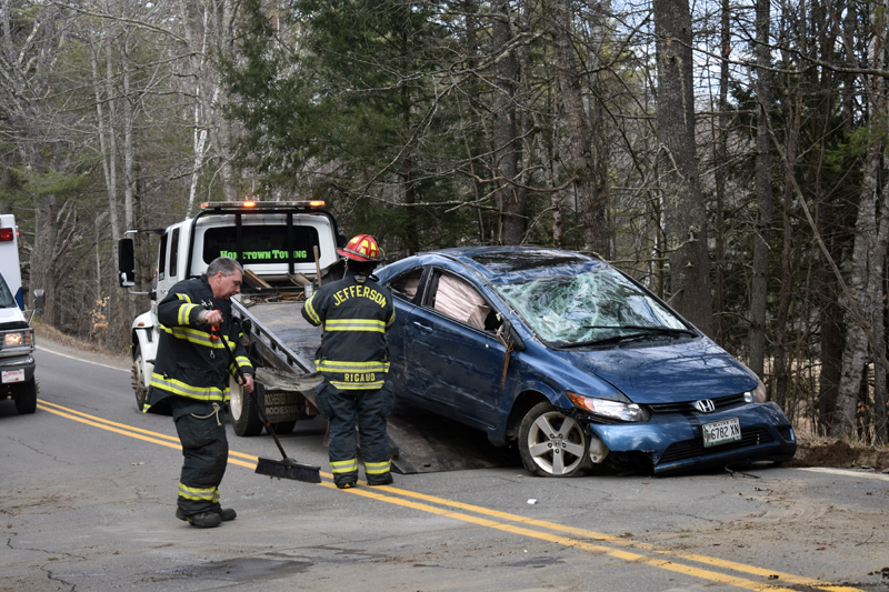 Firefighters sweep debris and help load a vehicle onto a tow truck after a crash on Bunker Hill Road in Jefferson the afternoon of Tuesday, April 7. (Alexander Violo photo)