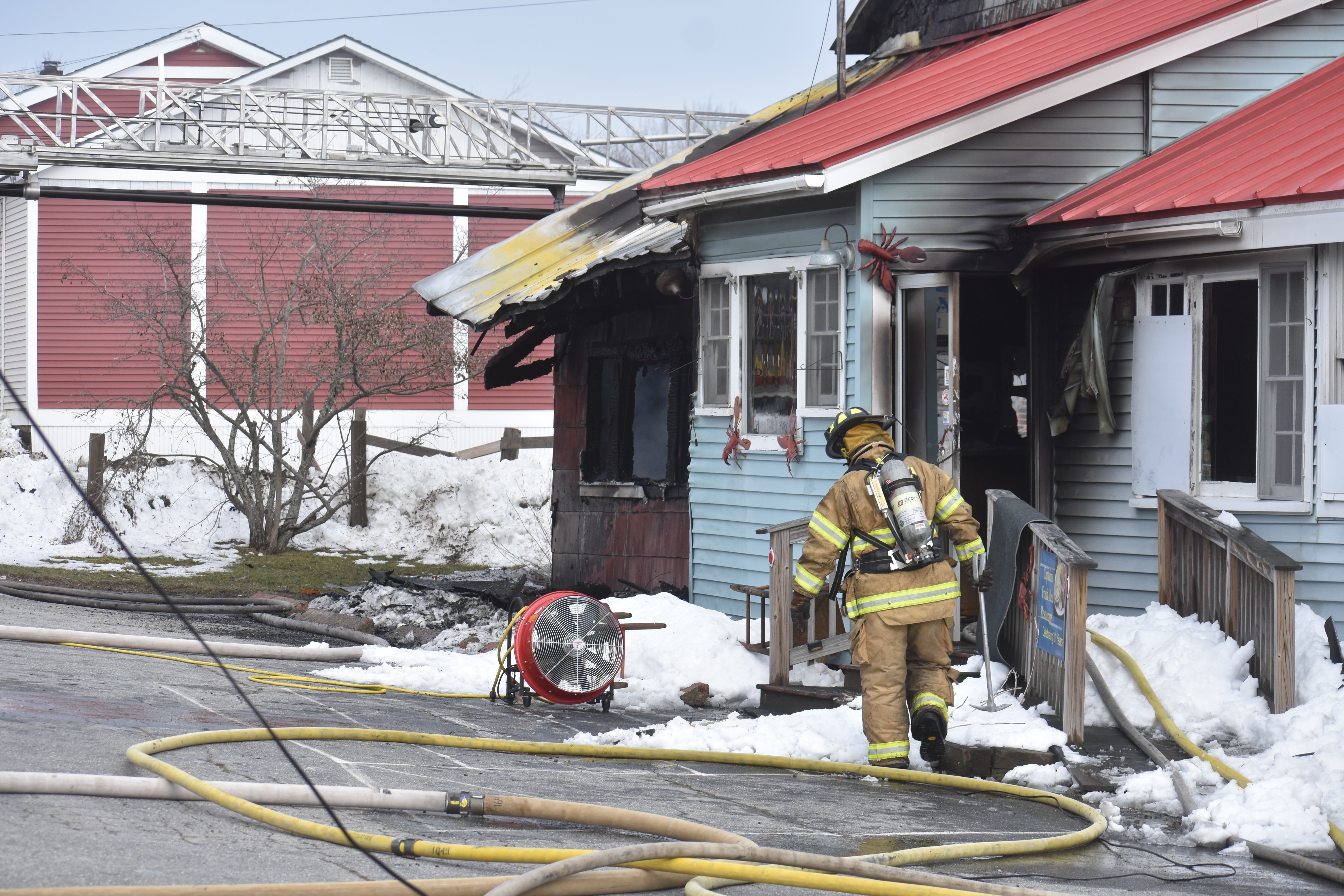 A firefighter works outside Captain’s Fresh Idea, on Route 1 in Waldoboro, the afternoon of Easter Sunday, April 12. Fire caused heavy damage to the interior of the building, according to Waldoboro Deputy Fire Chief Dale Smith. (Alexander Violo photo)