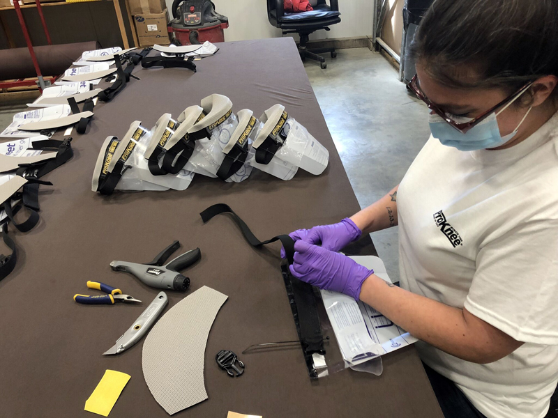 Miranda Pease, of Windsor, assembles a face shield with wick guard at ProKnee's manufacturing facility in Whitefield. (Photo courtesy Jordan Richards/ProKnee)