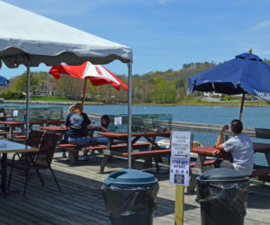 Lunch customers enjoy sun and seafood at Schooner Landing Restaurant and Marina in Damariscotta on Thursday, May 21. The restaurant is open for outdoor dining after a brief period with curbside pickup only. (Alyce McFadden photo)