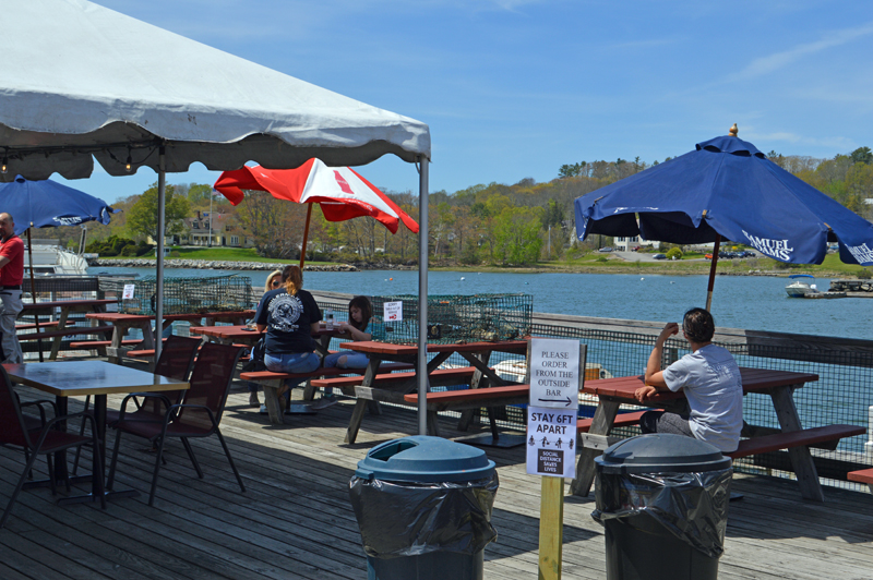 Lunch customers enjoy sun and seafood at Schooner Landing Restaurant and Marina in Damariscotta on Thursday, May 21. The restaurant is open for outdoor dining after a brief period with curbside pickup only. (Alyce McFadden photo)