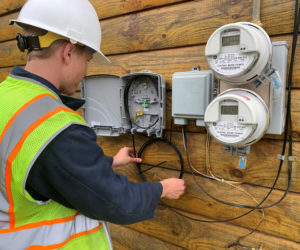 An employee of Nobleboro's Tidewater Telecom Inc. installs internet service outside a home. The company continues to conduct no-contact installations during the coronavirus emergency. (Photo courtesy Alan Hinsey)