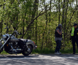 Douglas Humphrey (left) talks with Officer Cory Hubert at the scene of a motorcycle crash on Route 27 in Wiscasset, Wednesday, May 27. Police believe Humphrey's motorcycle and another motorcycle collided. (Evan Houk photo)