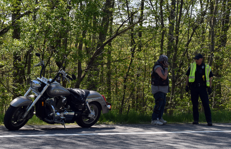 Douglas Humphrey (left) talks with Officer Cory Hubert at the scene of a motorcycle crash on Route 27 in Wiscasset, Wednesday, May 27. Police believe Humphrey's motorcycle and another motorcycle collided. (Evan Houk photo)