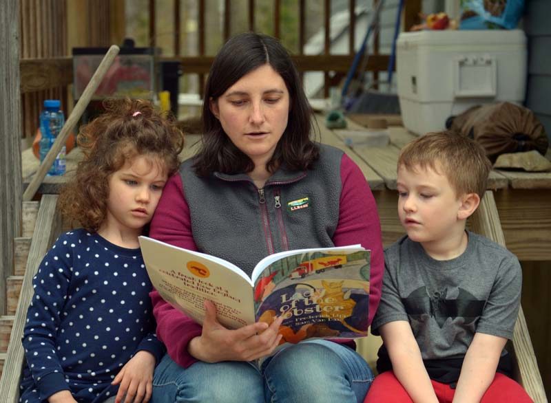 Allison Roberts reads "Lady of the Lobster," by local author Frederick Lipp, to her children, Michaela and James. (Paula Roberts photo)