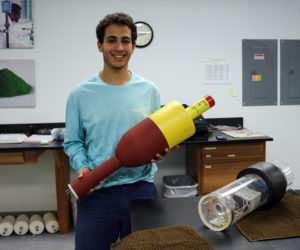 Joshua Girgis shows off a new low-cost environmental monitoring buoy he developed with a team at the Darling Marine Center in Walpole.