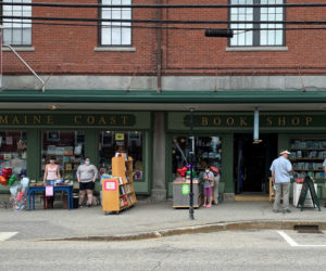 Customers browse bookshelves outside Sherman's Maine Coast Book Shop during the first open-air market in downtown Damariscotta, Saturday, June 13. The experiment aims to draw shoppers during the coronavirus pandemic. (Alyce McFadden photo)