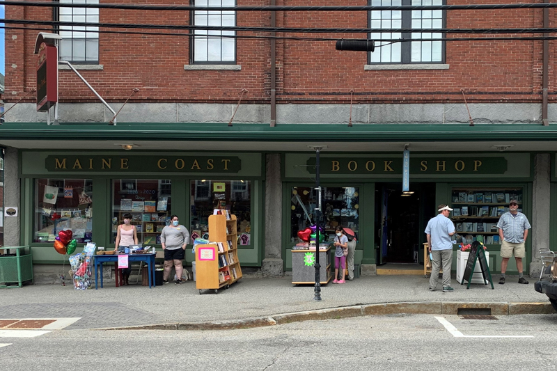 Customers browse bookshelves outside Sherman's Maine Coast Book Shop during the first open-air market in downtown Damariscotta, Saturday, June 13. The experiment aims to draw shoppers during the coronavirus pandemic. (Alyce McFadden photo)