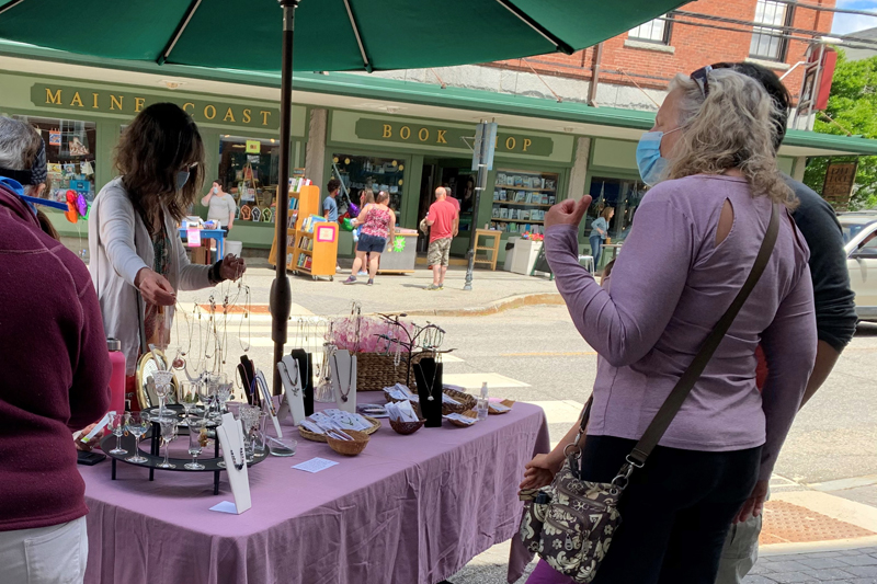 Aboca Beads owner Judy Dumont helps customers at her sales table on Main Street. (Alyce McFadden photo)