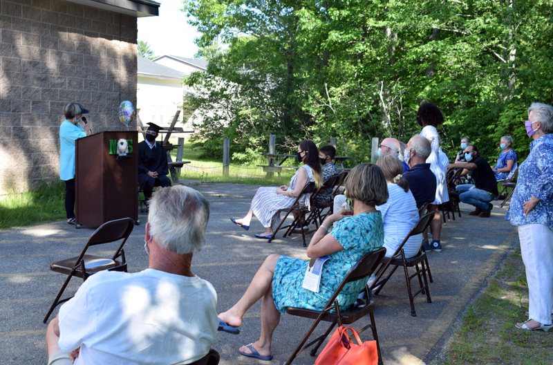 Central Lincoln County Adult Education Director Pamela Sperry addresses this year's lone graduate and a crowd of about 20 during a ceremony outside Nobleboro Central School on Thursday, June 18. (Evan Houk photo)