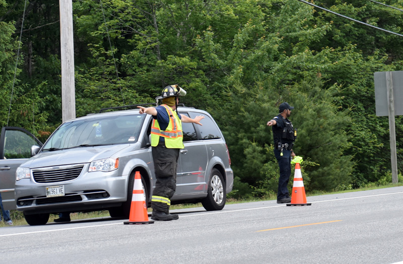 A Waldoboro firefighter and police officer direct traffic after a two-vehicle collision on Route 1, Tuesday, June 23. The minivan was one of the vehicles involved in the crash. (Alexander Violo photo)