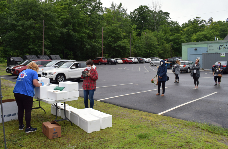 Customers wait in line to buy fresh seafood from the South Bristol Fisherman's Co-op stand during the first weekly fish market at Rising Tide Co-op in Damariscotta, Monday, June 29. (Evan Houk photo)