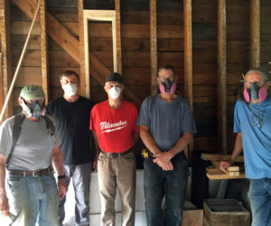 Volunteers and contractors wear masks for protection from dusty debris while renovating the building.