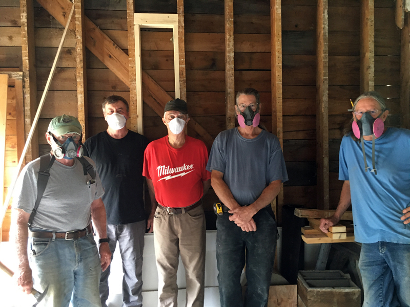 Volunteers and contractors wear masks for protection from dusty debris while renovating the building.