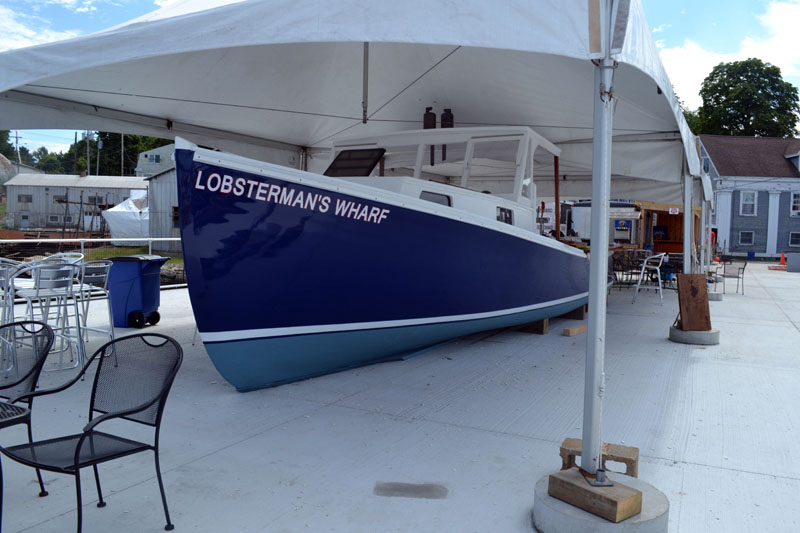 A lobster boat serves as a bar at Lobsterman's Wharf in East Boothbay. (Charlotte Boynton photo)