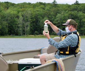 Peter Countway, a senior research scientist at Bigelow Laboratory for Ocean Sciences in East Boothbay, examines a water sample on Damariscotta Lake, Saturday, Aug. 15. (Evan Houk photo)