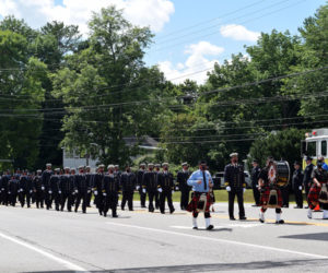 The Bergen County Firefighters Pipe Band and the Hackensack Fire Department, both of New Jersey, march on Route 1 in Wiscasset to honor Hackensack firefighter Richard Kubler. Kubler, 53, of Wiscasset, died July 25 of cancer linked to his service at ground zero after the 9/11 terrorist attacks. (Hailey Bryant photo)