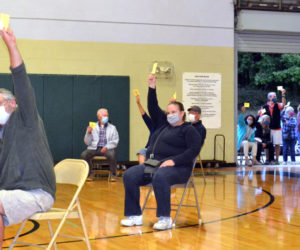 Voters inside and outside the Wiscasset Community Center gymnasium raise their cards to support the Wiscasset Parks and Recreation Department's budget during a special town meeting Thursday, Sept. 17. (Charlotte Boynton photo)