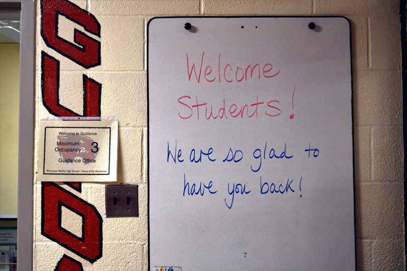 A message on a whiteboard outside the guidance office welcomes students back to Wiscasset Middle High School. Each room has a maximum occupancy sign outside the door. (Hailey Bryant photo)