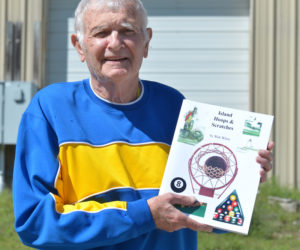 Walter White, of Waldoboro, holds a copy of his second sports history book, "Island Hoops & Scratches," which is about playing basketball and billiards on Vinalhaven. (Paula Roberts photo)