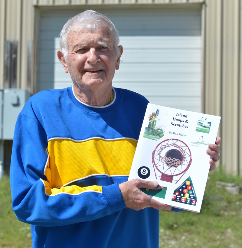 Walter White, of Waldoboro, holds a copy of his second sports history book, "Island Hoops & Scratches," which is about playing basketball and billiards on Vinalhaven. (Paula Roberts photo)