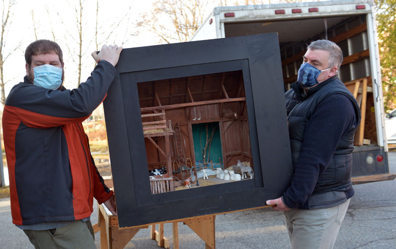 Allan Roberts and Justin Day carry Jake Day's barn diorama. The dioramas can be seen in the windows at Milling Around and the Damariscotta Region Chamber of Commerce. (Paula Roberts photo)