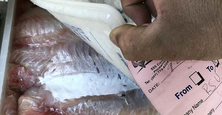 RSU 12 Nutrition Director Mike Flynn opens a container of fish from the Fishermen Feeding Mainers program. The program allows the district to serve fresh, local seafood to students. (Photo courtesy Food Management)