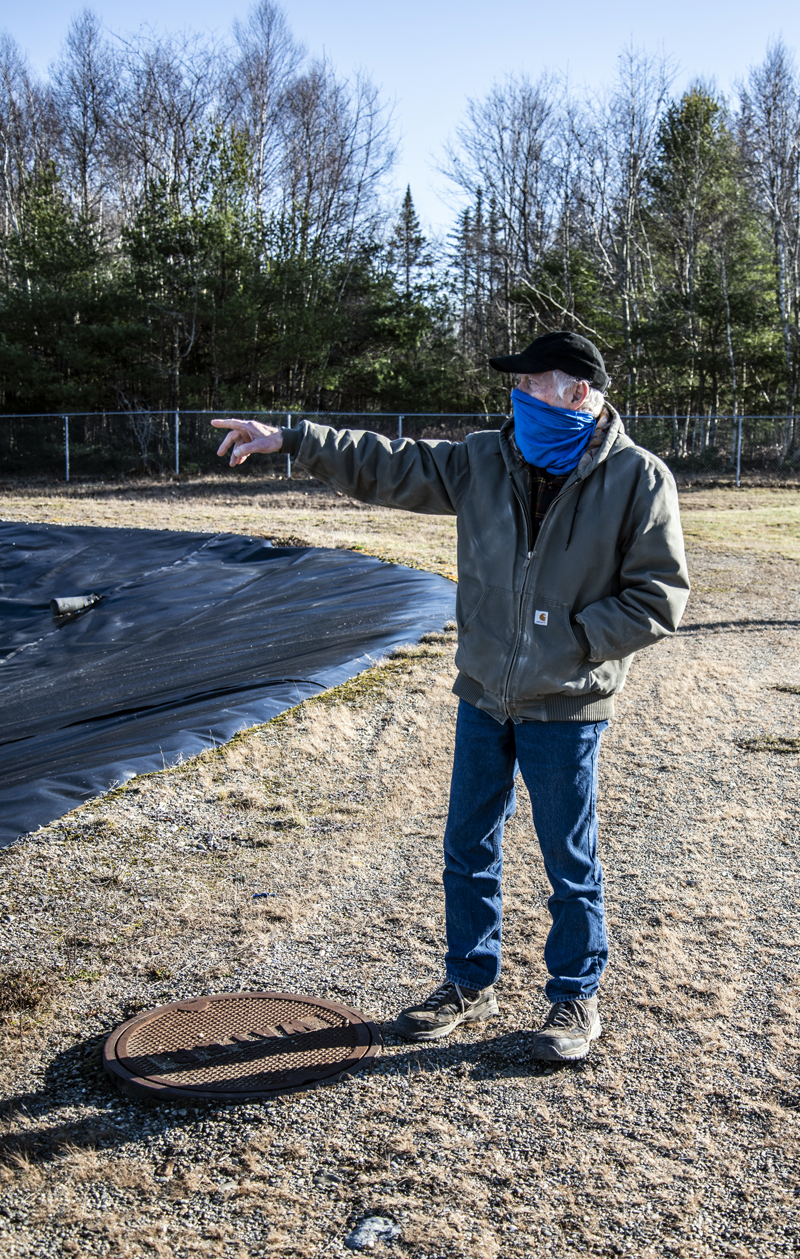 John Fancy points out the aeration system in the treatment lagoon in Waldoboro on Dec. 3. The cover near his feet is where Waldoboro's sewer lines ultimately converge to disperse the town's waste into the facility. (Bisi Cameron Yee photo)