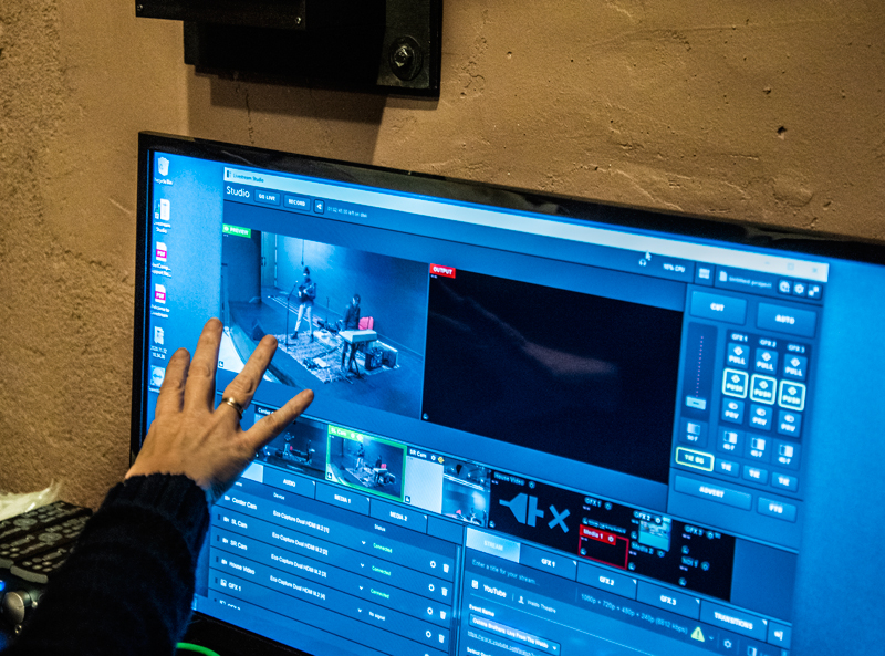 Kate Fletcher demonstrates the livestreaming system in the projection room at the Waldo Theatre in Waldoboro on Thursday, Dec. 3. The system has the ability to smoothly transition between three cameras that cover the extent of the stage. (Bisi Cameron Yee photo)
